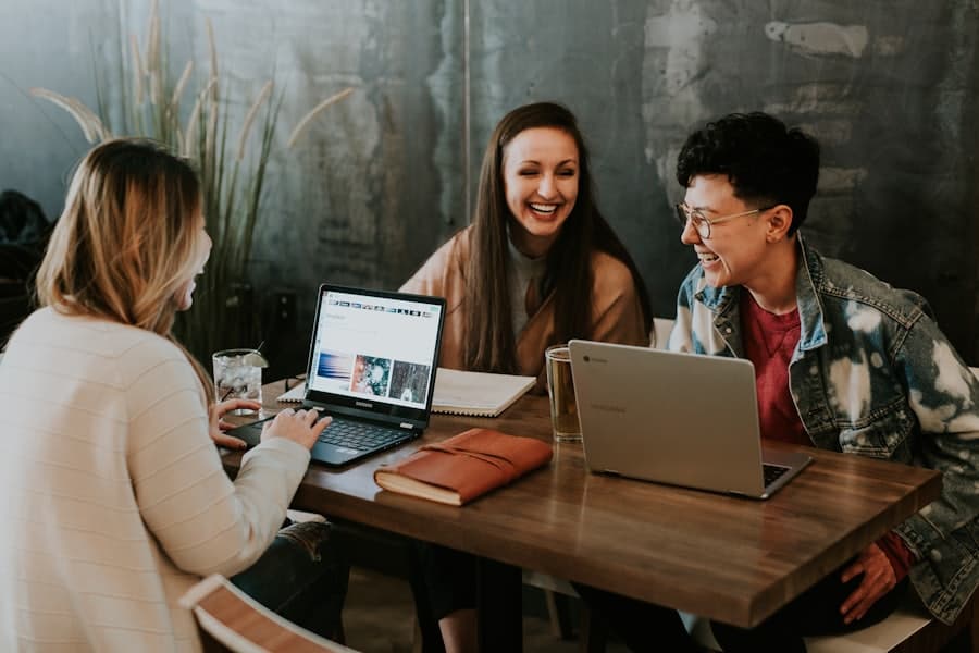 Three people planning together around laptops